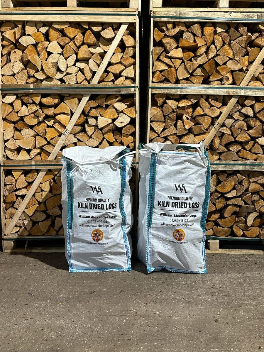 Two barrow bags of kiln-dried logs packed in front of the drying crates at the yard